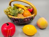 a bowl of fruit and two lemons next to each other