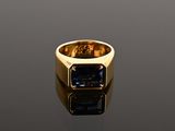 a close up of a gold ring with a blue stone