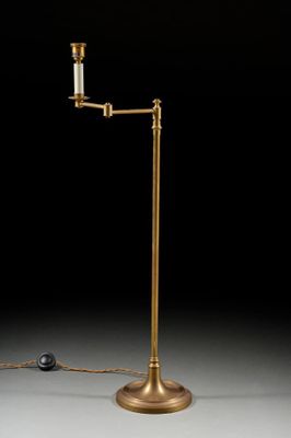 a brass plated floor lamp with a glass shade and a ball on the base