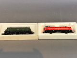 two miniature trains sitting in a box on a table