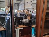 a large mirror in the middle of a room full of computer equipment