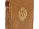 un vieux livre avec un emblème en or sur la couverture