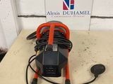 an orange and black air compressor sitting on top of a table next to a sign