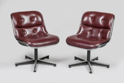 une paire de fauteuils de salon en cuir rouge montés sur roulettes, sur fond blanc