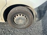 un pneu sale sur le côté d'une voiture blanche