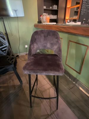 une chaise violette posée devant un bar
