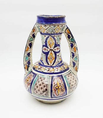 un vase bleu et blanc posé sur une surface blanche