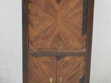 une armoire en bois à deux portes, avec un tiroir en dessous