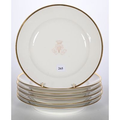 un service de quatre assiettes à bordure et décor dorés