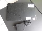 un ordinateur portable posé sur une table, avec un chargeur dessus