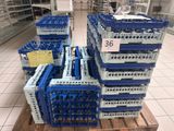 Plusieurs caisses bleues et blanches sont empilées sur une palette dans un magasin.