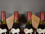 four bottles of wine are lined up in a row on a table