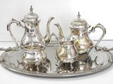 a silver tray with a silver tea set on it