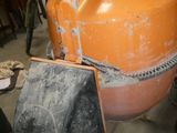 a large orange tank sitting on top of a cart in a garage