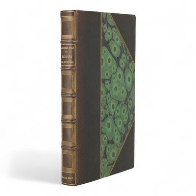 un vieux livre à la couverture verte posé sur une surface blanche