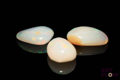 three white oplites sitting on top of a black surface