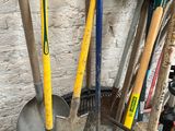 a pile of gardening tools and a shovel in a wheelbarrow