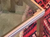 a glass table with a red rug on the floor