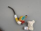 a figurine of a man smoking a pipe next to a teddy bear