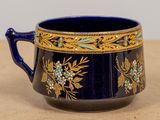 a blue cup with gold and blue flowers on it