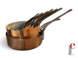 trois casseroles en cuivre avec leurs cuillères sont empilées les unes sur les autres