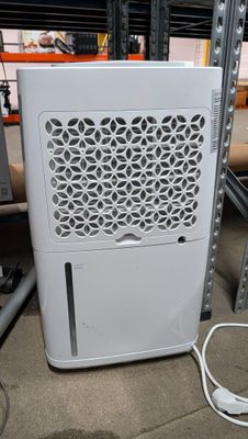 a white air conditioner sitting on the floor in a warehouse