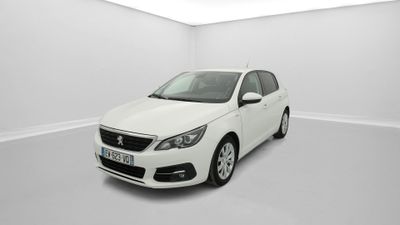 Une voiture blanche est garée dans une pièce blanche au sol blanc.