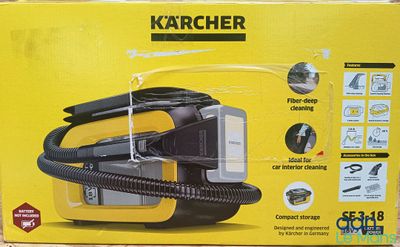 La boîte d'un aspirateur Karcher est ouverte sur la table.
