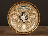 une assiette richement décorée posée sur une table en bois, sur fond noir