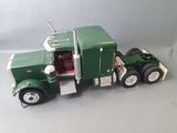 a green toy truck with a door open on a white surface