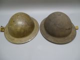 pair of british wwii era steel helmets, one with a helmet on the other