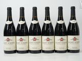 six bouteilles de vin sont alignées sur une table