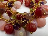 a close up of a multi - colored bracelet with gold chains