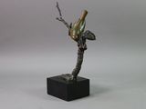 a statue of a bird perched on a tree branch