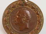 une image représentant une médaille de bronze sur laquelle figure la tête d'une femme