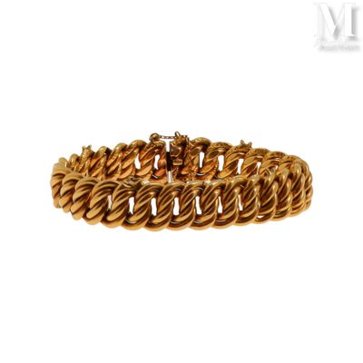 gros plan d'un bracelet en or sur fond blanc