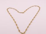 un collier à chaîne en or avec un fermoir en forme de cœur sur fond blanc