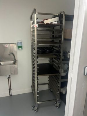 a metal rack with trays of food in a kitchen