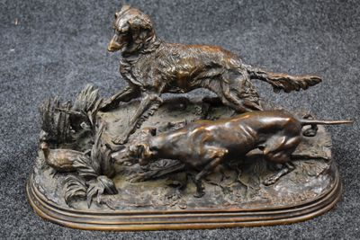 bronze statue of a dog and a cat on a rock