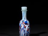 an image of a small glass bottle with red, white, and blue designs