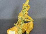 bronze figurine of a man sitting on a chair with a guitar in his hand