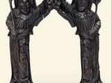 a statue of two women holding a basket of fruit