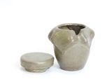 a small vase with a lid sitting next to a smaller vase