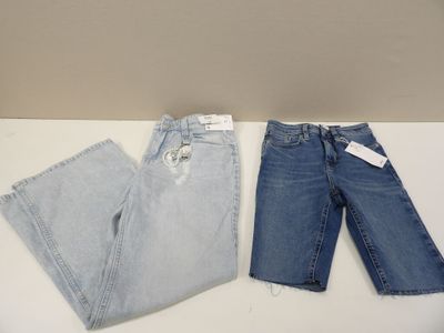 two pairs of jeans sitting on top of a white table