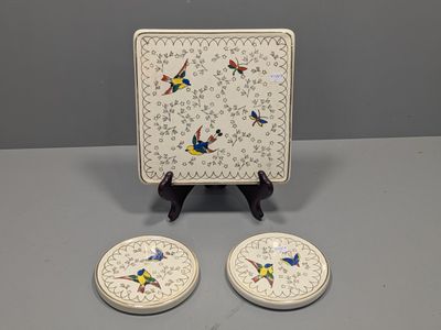 two small plates with birds on them sitting on a table