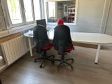 two chairs that are sitting in front of a white table