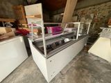 two refrigerators and a freezer sitting in a room