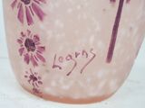 a pink vase with purple flowers on it sitting on a table