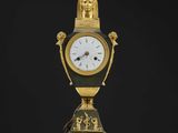 une image représentant une horloge dorée et noire posée sur une table