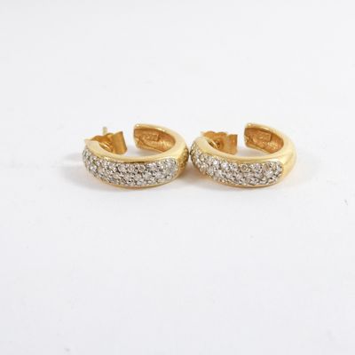 a pair of gold and diamond earrings on a white background